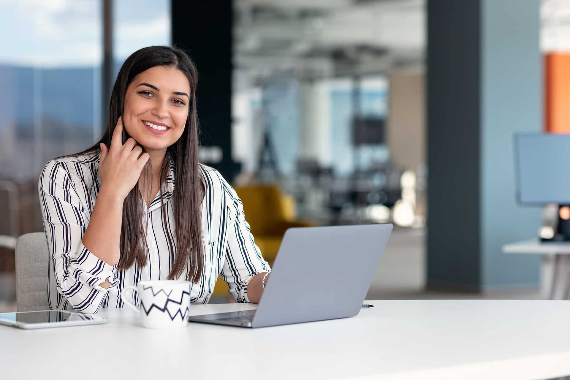 Professional woman in hijab standing confidently in an office