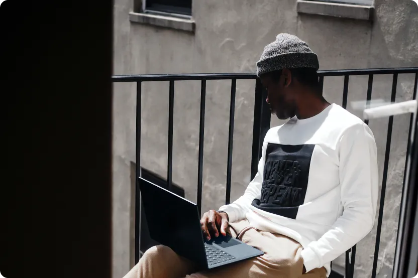 Professional man working remotely on a laptop, outdoor setting